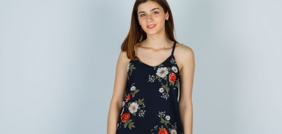 attractive lady in blouse posing while standing and looking optimistic , front view.